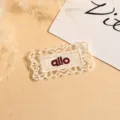 Nahaufnahme Detail des weissen spitzen bestickten Kleiderflicken Applikations Zubehörs - Rechteck / Beige