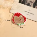 Detailed close-up view of a cute brown bear and red strawberry embroidered patch item. - Style 5
