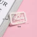 Gedetailleerd overzicht van een schattige mesh geborduurde strik stofpatch voor kledingdecoratie. - Stijl 4