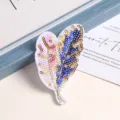 Close-up of sparkling sequin feather patch, detailed embroidery for clothing decoration. - Feather Style
