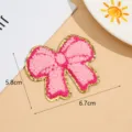 Roze chenille strik borduurwerk patch detail, goud rand decoratieve patch, close-up. - Stijl 1