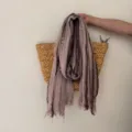 Close-up detail of the rustic striped cotton-linen scarf with raw fringe edges, texture view. - Dusty Pink
