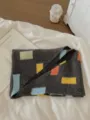 Close-up detail of the cozy knitted scarf featuring colorful geometric patches and soft texture. - Color Block Triangle Scarf / Color Block Triangle Scarf Dark Gray