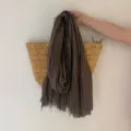 Gros plan d'écharpe marron foncé avec texture fine, détails de franges effilochées et style rétro. - Café
