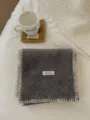 Detalle de bufanda de punto gris acogedora de invierno con bordes blancos de contraste. - Gris