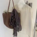 Detail view of the artistic wrinkled color-block linen scarf styled with bag and blouse. - Large Polka Dot Patchwork Purple
