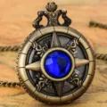 Closeup view of vintage bronze pocket watch featuring a blue crystal center and Roman numeral dial. - Thin Chain / Blue Stone - Fine Chain
