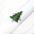 Detail view of the sparkling green Christmas tree napkin ring resting on a white napkin. - Christmas Tree