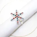 Primo piano di un portatovagliolo a fiocco di neve argentato con strass rossi e blu dettagli - Stile con motivo a fiocco di neve