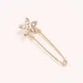 Crystal flower brooch detail shot, elegant gold alloy safety pin for waist and clothing fix. - Five Marquise Rhinestone Pin
