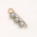 Detail shot of a gold-tone safety pin brooch featuring three grey pearls and sparkling rhinestone spacers. - Eraser / 5.8cm / Gray