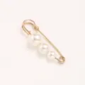 Close-up detail of a gold safety pin brooch decorated with three graded white pearls. - Gold Pin Graduated Pearls / 5.50cm