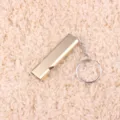 Close-up detail of the portable double-tube aluminum alloy whistle with a convenient keyring. - Gold