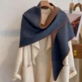 Detail shot of a thick triangular shawl with contrast edges draped over a stylish coat for winter. - HSJ-2-Blue Coffee