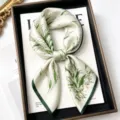 Detailed view of a luxurious mulberry silk square scarf with elegant green botanical print. - Wind Meets Lily of the Valley / 68cm