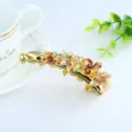 Pince banane dorée pour cheveux en alliage avec fleurs en émail coloré et strass scintillants. - Café