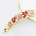 Detailed view of gold-tone banana hair clip with enamel pink flowers and sparkling crystals. - HB00740 / Pink