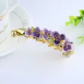 Gold-tone alloy banana hair clip featuring purple painted enamel flowers and sparkling rhinestones. - Purple