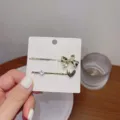 Joli set de barrettes à cheveux dorées en métal avec un nœud et un cœur en strass brillants. - RY08995