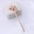 Détail exquis d'épingle à cheveux en alliage doré, strass roses étincoyants et élégantes chaînes de pampilles. - Rose