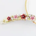 Gros plan d'une pince banane dorée en alliage avec des fleurs émaillées roses et des strass. - HB00739 / Rose