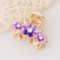 Pince à cheveux en métal doré avec fleurs en émail violet et strass en cristal scintillants. - Violet