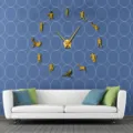 Detailed scene of a golden 3d acrylic mirror football wall clock mounted in living room. - Gold