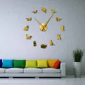 Detailed view of DIY acrylic cat wall clock on grey wall with modern sofa and green plant decor. - Gold