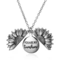 Close-up detail of silver alloy sunflower locket necklace with inspirational engraved quote. - Silver