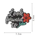 Detailansicht des schwarzen gestickten Aufnähers mit dem Text Look forward to und rotem Blumendesign. - Blumen Slogan Stil (XD9201-1)