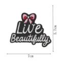 Detaillierter bestickter Aufnäher mit Live Beautifully Schriftzug und rosafarbener Schleife. - Schleife Live Beautifully (DW9212-7)