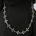 Detail van de zilveren metalen kruis ketting als stijlvol accessoire voor broeken en taille. - Zilveren Broekketting