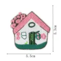 Vue détaillée de l'écusson brodé en forme de mini maison mignonne avec toit rose et fleurs. - Style DW9196-9