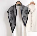 Vue détaillée du foulard triangulaire en serge de soie noire et blanche sur un vêtement blanc. - 135x80cm / RY-51