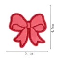 Close-up detail of pink embroidered bow patch with red border for clothing decoration and repair. - DW9806-29