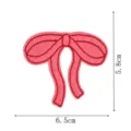 Close up view of pink embroidered bow patch, detailed stitching, clothing repair accessory. - DW9806-32