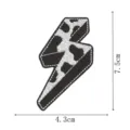 Close-up detail of the black and white cow print lightning bolt embroidered patch with clear edges. - Cowboy Lightning(DW9804-46)
