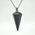 Gedetailleerde close-up van de zwarte kristallen hanger met metalen dop en bijbehorende ketting. - Obsidiaan Zilverketting