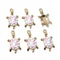 Close-up details of golden alloy enamel turtle charms showing cute pink shell design for DIY crafting. - F6-30