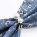 Detail en gros plan d'un anneau de serviette a perles doubles avec tissu elegant. - Or