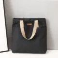Detailed view of the black canvas tote bag with sturdy handles, daily casual commuter bag. - Black