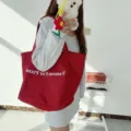 Red canvas tote bag detail featuring white graphic text print, casual shoulder bag design. - Red Single Shoulder