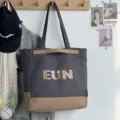 Detailed view of canvas tote bag with letter print and contrast design for daily use. - Top Handle Bag / Black