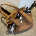 Brown suede shoulder tote bag featuring black and white checkered lining and charms. - Without Pendant / Horn Buckle Suede Tote Bag / Brown