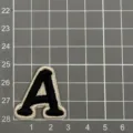 Nahaufnahme Detail des schwarz-weißen gestickten Buchstaben A Aufnähers auf Matte. - Buchstabe A (4A5-1)