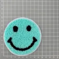 Close-up of mint green round smiley face towel embroidery patch with black facial details. - Cyan Smiley Face (1C7-1)
