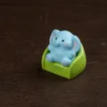 Cute miniature blue elephant figurine sitting on a green sofa resin desktop decor ornament. - Sofa Elephant
