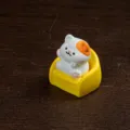 Miniature white orange cat figurine sitting on yellow sofa, cute desktop ornament for decor. - Sofa Kitten