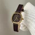 Close-up of the small polygonal gold dial and dark brown leather strap women quartz watch. - Litchi Texture Style / Dark Coffee Gold Frame Litchi Pattern