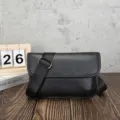 Dettaglio della borsa a tracolla rétro da uomo in pelle morbida nera con cinghia. - 5 Pollici / Tutto Nero
